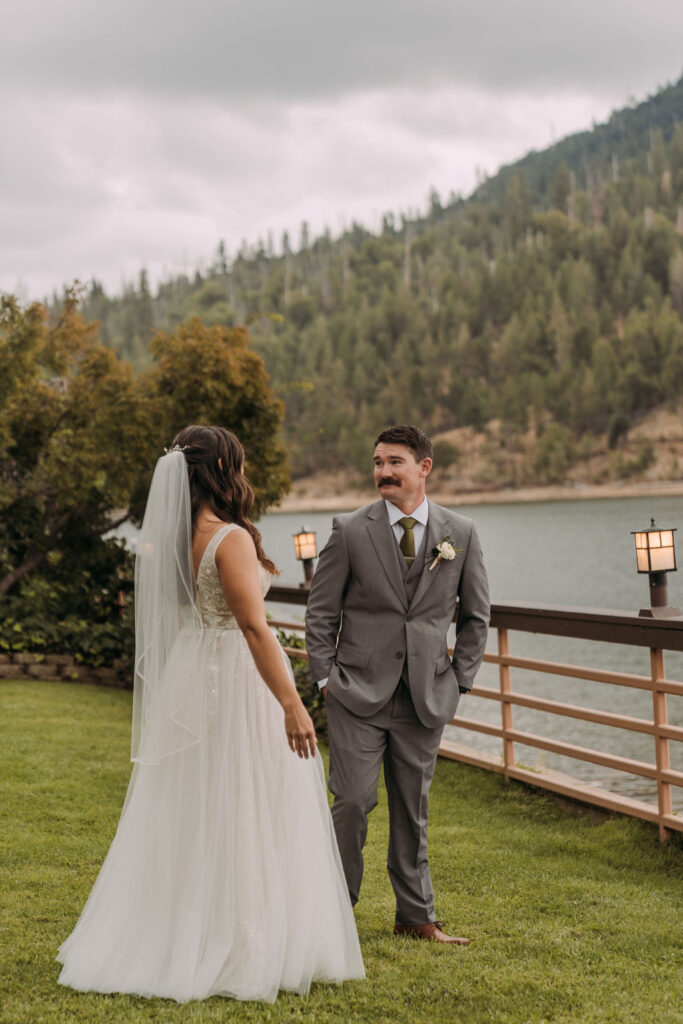 bride and groom first look with lake and forest views