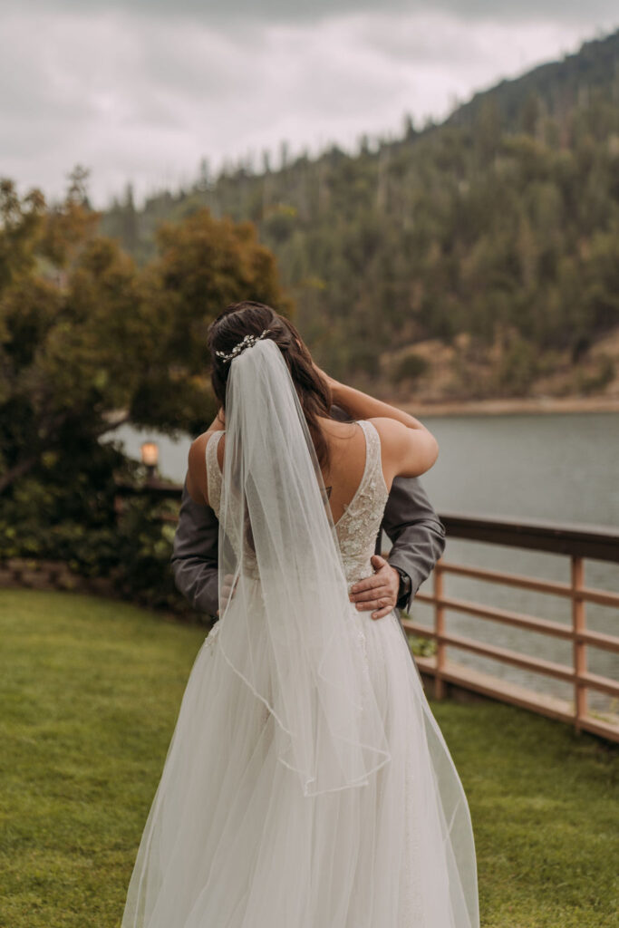 bride and groom first look with lake and forest views